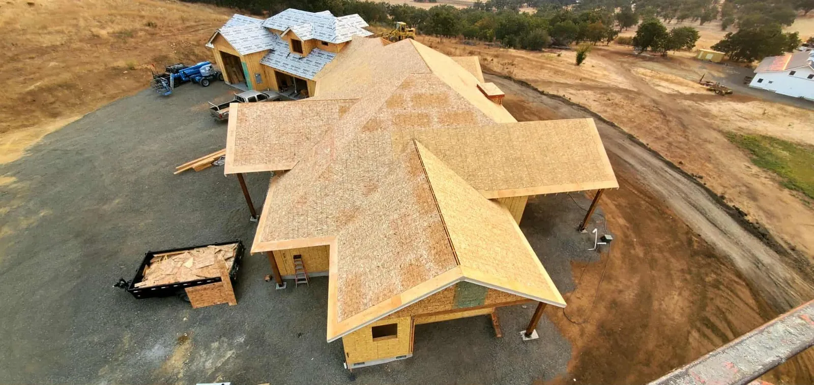 Aerial view of a new multi-gable roof being decked on a Southern Oregon home, Next Gen Contracting roofing project